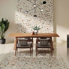 a dining room table and chairs in front of a wall with mosaic tiles on it