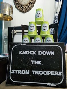 a star wars themed party with green and white cups in front of a sign that says knock down the storm troopers