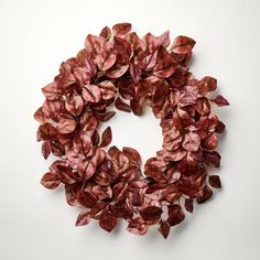 a wreath made out of red leaves on a white surface