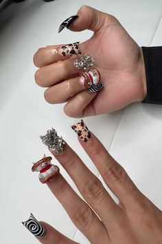 a woman's hands with different nail designs on their fingers and one holding an object in her hand