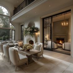 an elegant living room with large windows and white furniture in front of a fire place