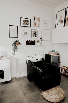 a black chair in a room with pictures on the wall