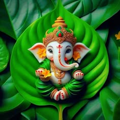 an elephant statue sitting on top of a green leaf