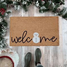 someone standing in front of a welcome mat with a snowman on it and the words welcome