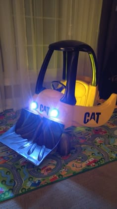 a toy car that is sitting on the floor with its lights on and it's hood up