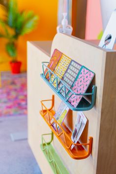 a wooden counter topped with lots of magnets on it's sides and hooks