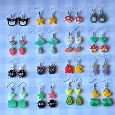 a collection of earrings with different designs on them, including cats and owls in various colors