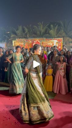 a group of people standing around each other on a red carpet in front of a crowd