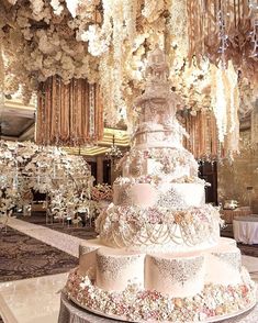 a large white cake sitting on top of a table next to a chandelier