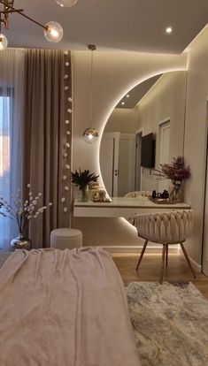 a bedroom with a large mirror, vanity and dressing table in front of the window