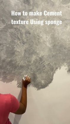 a woman painting a wall with gray paint and the words how to make cement texture using sponge