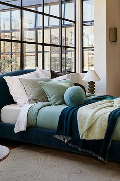 a bed sitting next to a window in a bedroom