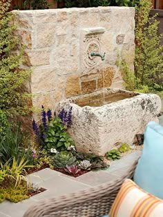 a stone fountain surrounded by plants and flowers