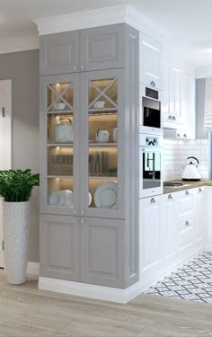 a large kitchen with white cabinets and wood flooring, along with a dining room table