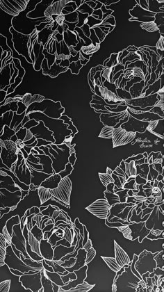 black and white drawing of flowers on a wall with chalkboard writing in the background