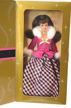 a barbie doll in a pink and black dress with white fur collar, plaid skirt and matching shoes