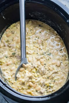 a slow cooker filled with chicken and bean soup