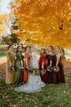 a group of women standing next to each other in front of a tree