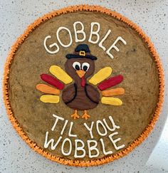 a decorated cookie with the words gobble til you wobble on it and a turkey