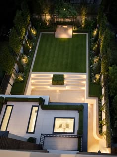 an aerial view of a backyard at night with lights on the lawn and seating areas