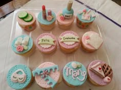 cupcakes decorated with different types of items on a clear plastic tray that says tell it's congratulations