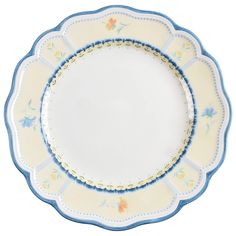 a white plate with blue trim and flowers on the rim, sitting in front of a white background