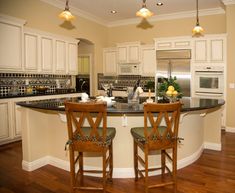 two wooden chairs sitting at the center of a kitchen island