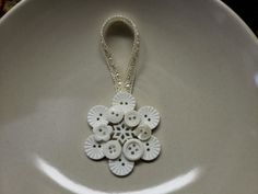 a white plate topped with buttons and a necklace on top of it's side