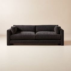 a black couch sitting on top of a white floor