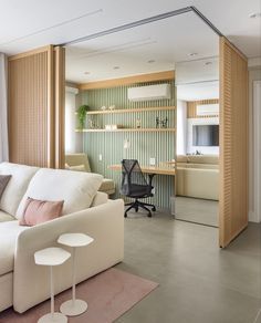 a living room filled with furniture next to a wall covered in wooden slatting