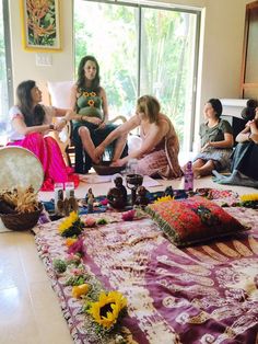 a group of women sitting on top of a floor next to each other in front of a window