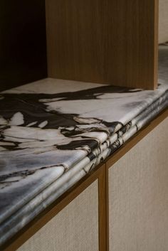 a marble counter top with wooden cabinets in the background