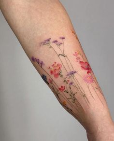 a woman's arm with flowers painted on it