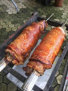 two large meats are being cooked on a grill