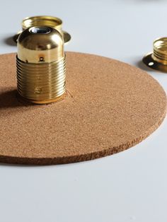 a cork board with two brass knobs on it and some gold plates around it