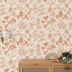 an orange and white wallpaper with mushrooms, leaves and flowers on the sideboard