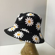 Womens bucket hat or sunhat is a fresh looking black hat with a white daisy design.  The hat will fit average sized heads, and has an inside elastic cord for adjusting.  It is lined.  The brim is topstitched, and can be worn up at the front or back, or all around for a different look.  A great casual hat  that can be folded or rolled to keep in your bag.  Please check your head measurements. Measurements  Inside60cms.     23 1/2" Brim6.5cms.      2 1/2" White Cotton Bucket Hat For Summer, Summer Bucket Hat One Size Fits Most, White Summer Bucket Hat, One Size Fits Most, Trendy Cotton Bucket Hat For Summer, Trendy Summer Bucket Hat With Short Brim, Black Cotton Sun Hat For Vacation, Summer Cotton Hat In Black, Black Cotton Bucket Hat For Vacation, Summer Black Cotton Hat