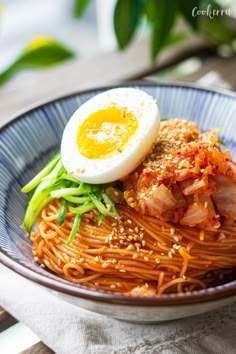 a bowl filled with noodles and an egg on top