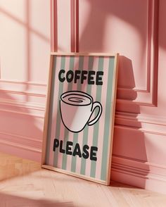 a coffee sign is on the floor next to a pink wall with a striped frame