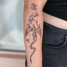 a woman's arm with a dragon tattoo on the left side of her body