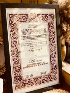 an ornate framed certificate is displayed on a table next to some flowers and other decorative items