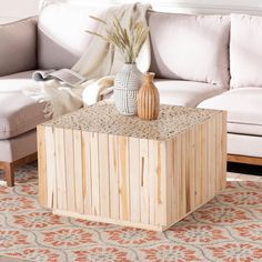 a living room with a couch, coffee table and rug on the floor in front of it