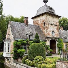 an old house with hedges in front of it