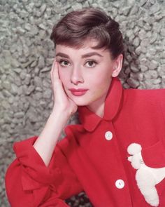 a woman with short hair wearing a red shirt and white poodle on her lap