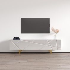 a white tv stand with a vase on it