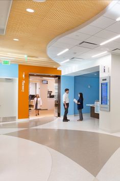 two people are standing in an office lobby