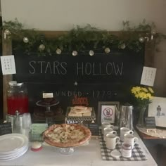 a table topped with lots of food next to a chalkboard that says stars hollow