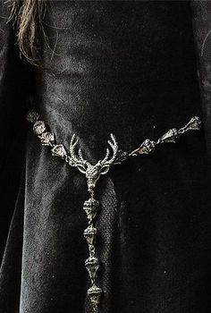 a close up of a person wearing a black outfit with a chain around the waist