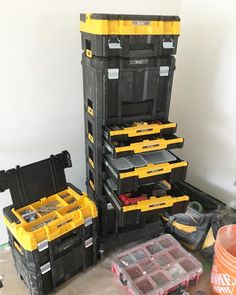 several black and yellow tool boxes stacked on top of each other with tools in them