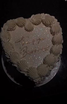 a heart - shaped cake with white frosting that says happy birthday